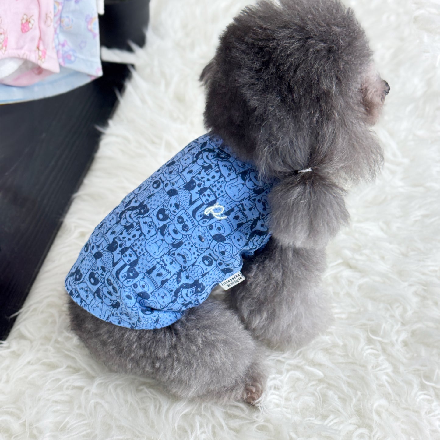 Luna (Silver Teacup Poodle) wearing a dark blue top with dog print pattern - Puppy Palooza Sleeveless Tee (also available in other designs) sold at Velymon SG, sitting in a changing room setting.