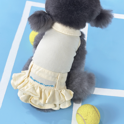 Luna (Silver Teacup Poodle) wearing the Yellow Tennis Polo Dress (Available in 3 Colours) sold at Velymon SG sitting in a Blue Tennis Court
