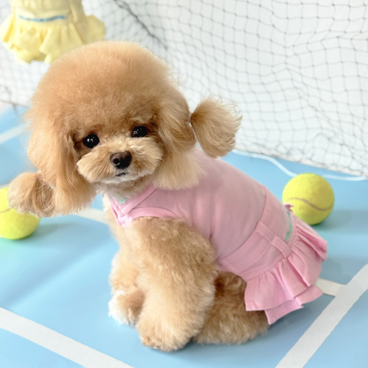 Mui Mui (Apricot Tiny Toy Poodle) wearing the Pink Tennis Polo Dress (Available in 3 Colours) sold at Velymon SG sitting in a Blue Tennis Court

